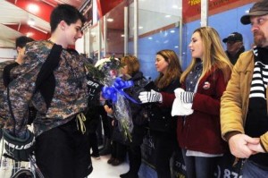 From left, Abington High School's Jacke Morse gives Erin Vasselian, the wife of Daniel, a bouquet of flowers, Karen Vasselian (mom of Daniel), also got flowers. Abington High School hockey team honored United States Marine Sgt. Daniel Vasselian before their hockey game on Saturday, Jan. 10, 2015. The game was against rival Rockland High School.  The Abington High School hockey team wore camouflage jerseys and Danny's brother Joe did the ceremonial puck drop before the game.  Also  Massachusetts state police Sgt. Tim Grant sang the National Anthem.   (Marc Vasconcellos/The Enterprise)