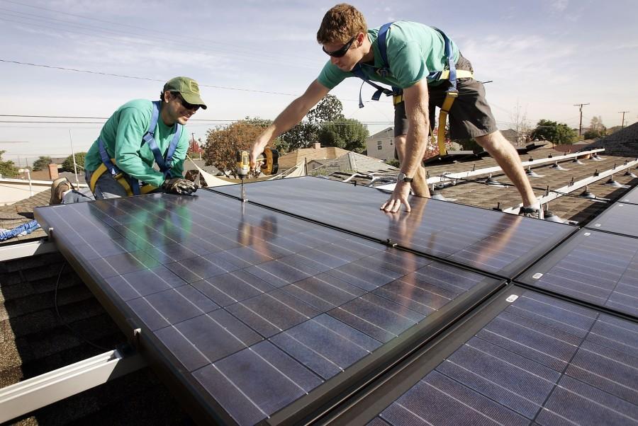 Joey Ramirez, left, and Taran Stone with SolarCity install solar modules on the roof of a Long Beach, Calif., home. Florida has a ton of sunshine, a ton of rooftops, a SolarCity spokesman said. But there is no rooftop solar industry in Florida. (Al Seib/Los Angeles Times/MCT)