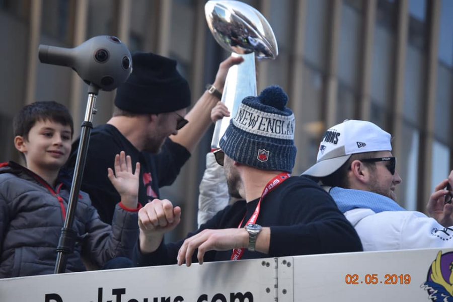 Benjamin Brady smiles and waves to the crowds in Boston while father and Patriots quarterback Tom Brady (with trophy) hoists one of NEs six championship trophies on Tuesday, February 5, 2019.