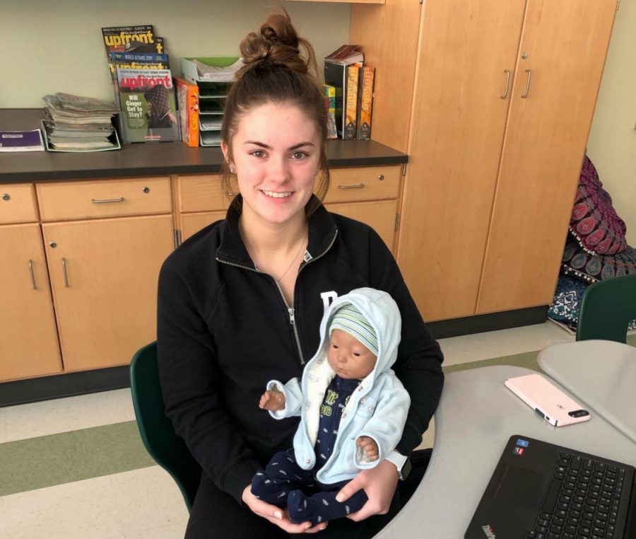 Senior Hailey Holmes holds her baby which she was assigned in early March 2019 in her Child Development class at Abington High School for the Baby think it over project.
