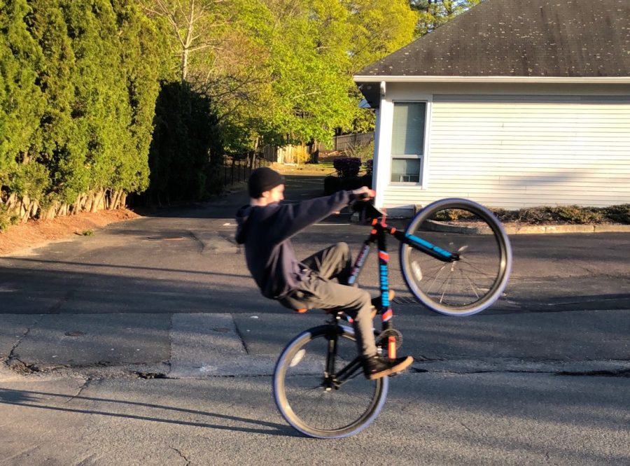 Abington High School freshman Christian Waterman doing a wheelie on his black, orange, and blue color schemed 2018 Big Flyer. 