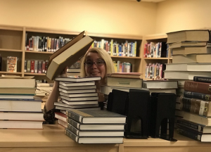 Mrs. London working very hard to reorganize the library and make it easier for students to find the books they need in the Middle-High School Library in October of 2019.