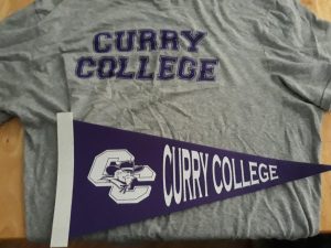 Curry Colleges athletic teams are known as the Colonels. The schools colors are purple and white, as shown in this pennant and T-shirt with Curry Colleges insignia.