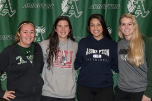Softball coaches Kristen Reardon (left) and Kelsea Cheney (right) with seniors Lauren Keleher (BU) and Corin Mahan (Assumption) during the Letter of Intent signing held after school at Abington High School on November 18, 2019.