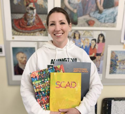 Ms. Michelle Poirier holds some of the course catalogs from colleges she invites to her art classroom at Abington High School. Recently several art colleges came to speak to her students about a career in art. 