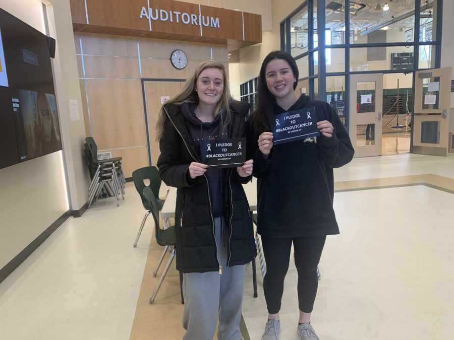 Abington High School seniors Keriann Danahy and Lauren Kelliher promote the Blackout Cancer pledge cards while standing outside of the high schools gym. Both Danahy and Keleher are members of the Student Athletic Advisory Council (SAAC) and helped to organize this event.