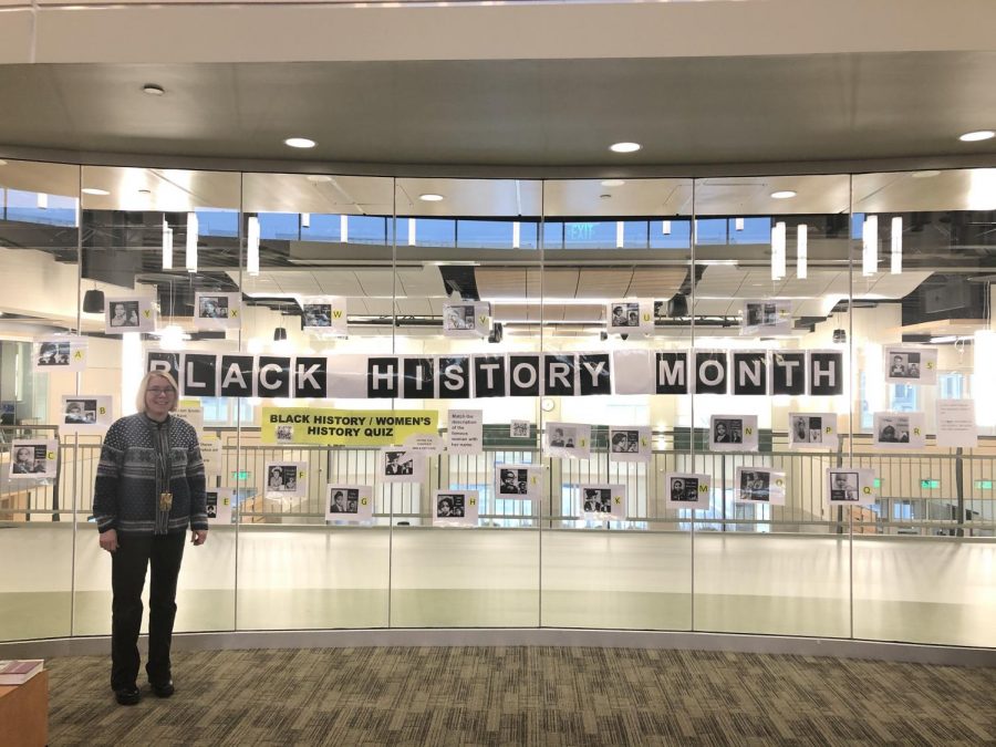On Tuesday, February 11, 2020, Abington Middle-High School Library and Media Specialist Mrs. London stands inside the library. On the glass is the photo contest to celebrate Black History month.