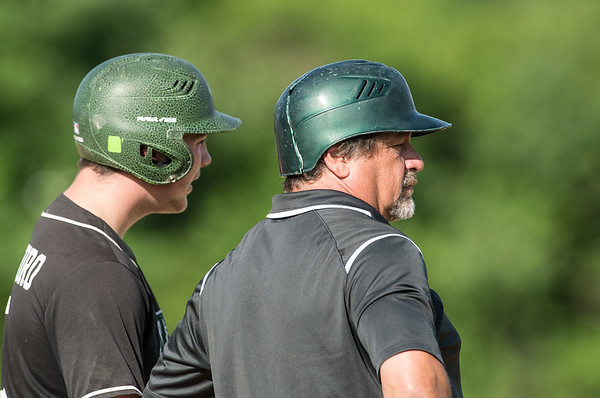 Brady Cristoforo, a junior at Abington High (left) and head coach Steve Perakslis (right) have a conversation on third base on June 17, 2019 in a showdown against St. John Paul at Braintree High School.