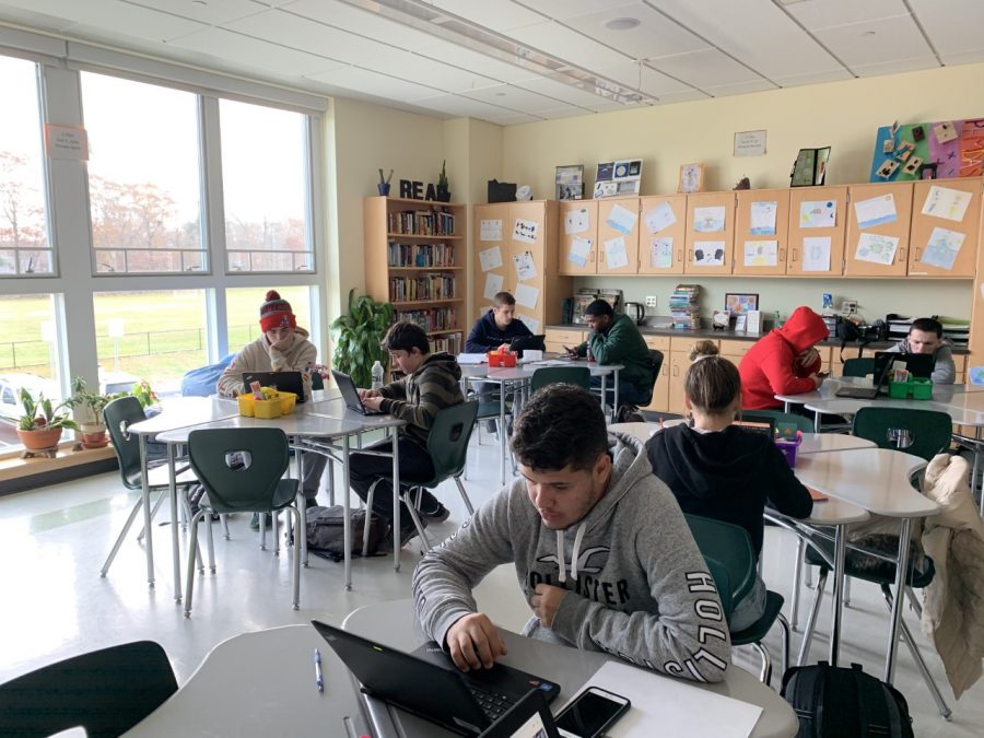 Senior Joao Carlos Andrade (front) works on his classwork in Bridge Block at Abington High School  fall of 2019.