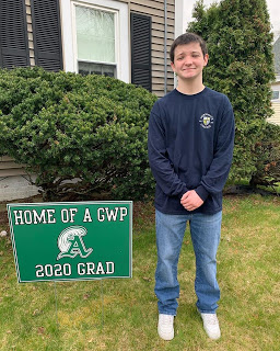 Bubba Gendreau stands in front of a Green Wave Pride sign that the Class of 2020 advisors placed on student lawns. Gendreau has committed to attending Merrimack College this fall.