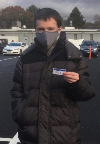 Abington High School senior James Mulkern holding his first I Voted sticker outside his local polling station on Tuesday, November 3, 2020.