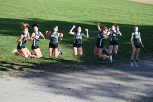 The Abington High School Girls Cross Country team leap for joy at their meet against Middleborough on October 21, 2020.