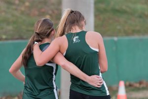 Maddi Carini supports an injured Hannah Tirrell as they make their way to the finish line at their meet against Randolph on November 20, 2020.