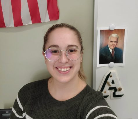 Ms. Megan Tomlin in her English classroom at Abington High School on March 9, 2021. Tomlin stands in front of a photo of Charles M. Frolio, whose name was on the former middle school in town. Tomlin, and AHS alumna, also taught at and attended the Frolio Middle School. 