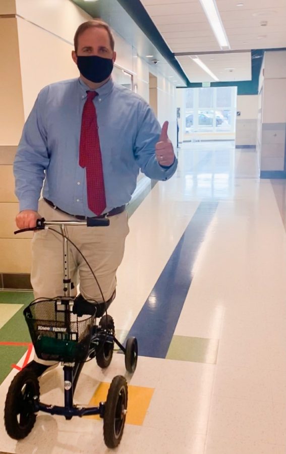 Mr. Jonathan Bourn, principal at Abington High School scootering though the hallways on March 11, 2021. 