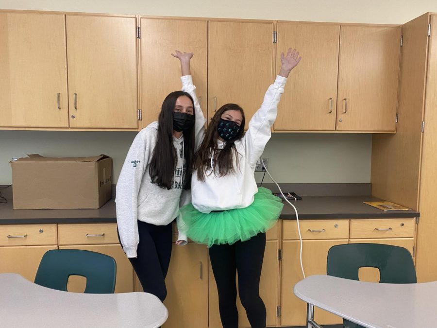(left to right) Seniors Erin Doherty and Lyla Blanchard wearing their Green Wave Pride on their sleeves as they pose for a picture during a break in their AP Literature and Composition class on April 30, 2021 at Abington High School.