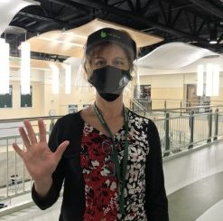 Ms. Karin Sanborn, a paraprofessional at Abington High School, gives a high five while standing in the schools rotunda on March 26, 2021.